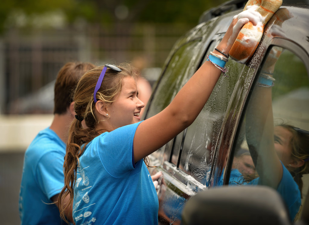 Mikayla Shockley, 13, helps wash one of the cities cars in the parking lot of the Fullerton Police department, part of the Love Fullerton community event. Photo by Steven Georges/Behind the Badge OC