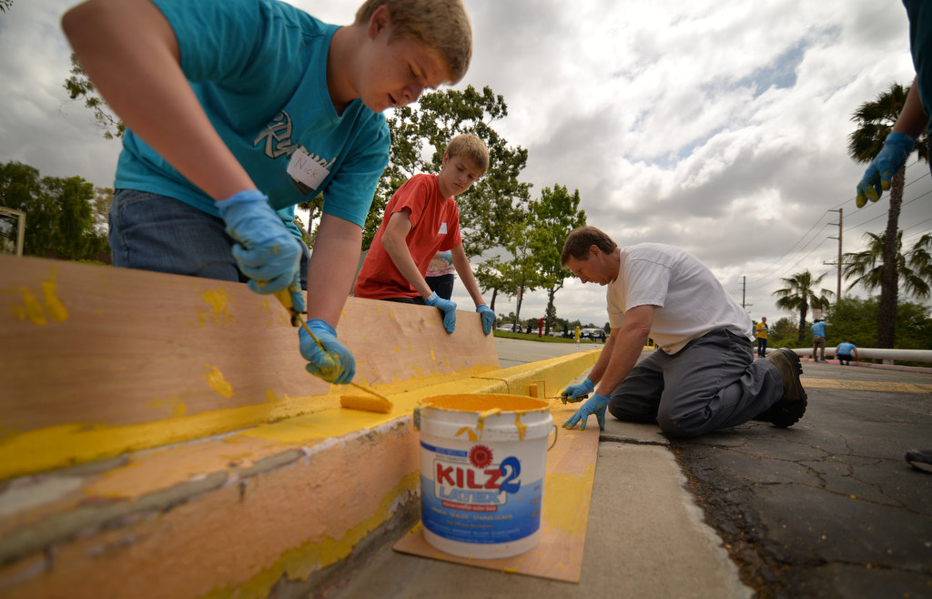 Nicholas Gudmundsen, 15, left, and his twin brother Andrew Gudmundsen, both Sunny Hills High students, volunteers their time to repaint the curbs as Sunny Hills High yellow with their dad, David Gudmundsen, during the Love Fullerton community event. Photo by Steven Georges/Behind the Badge OC