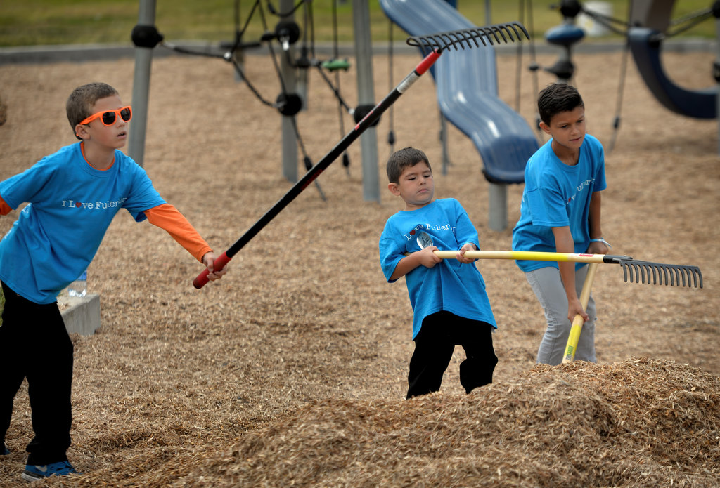 Volunteers help spread playground chips at Independence Park in Fullerton during the Love Fullerton community volunteer event. Photo by Steven Georges/Behind the Badge OC