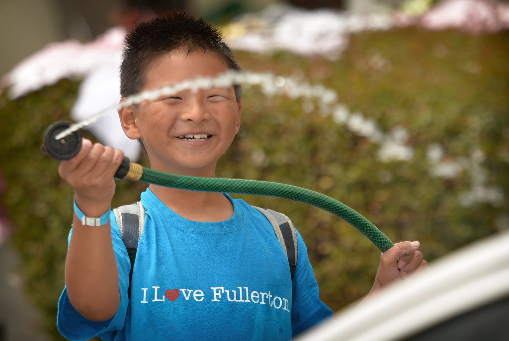 Jonathan Chien, 9, of Yorba Linda, helps wash one of the cities cars in the parking lot of the Fullerton Police department, part of the Love Fullerton community event. Photo by Steven Georges/Behind the Badge OC