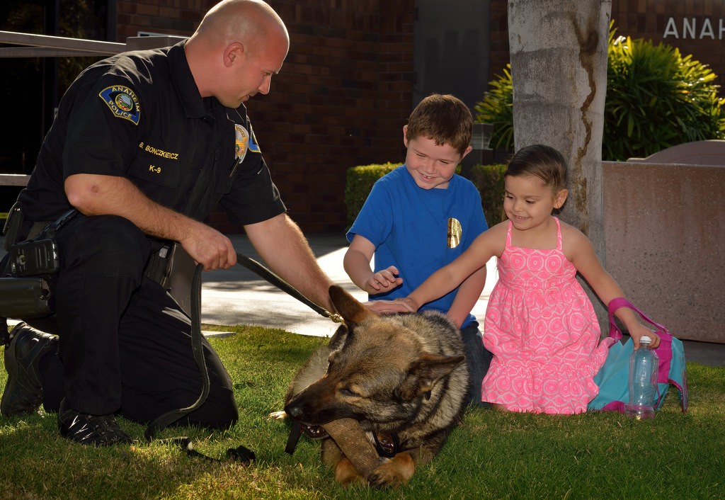 Jason, 7, and his sister Jessie, 4, of Anaheim, come up and pet, with Anaheim PD Officer Brian Bonczkiewicz’s permission, Ivan, who assisted in the detainment of a freeway chase suspect a week earlier responsible for the closure of the 91 freeway in both directions. Photo by Steven Georges/Behind the Badge OC