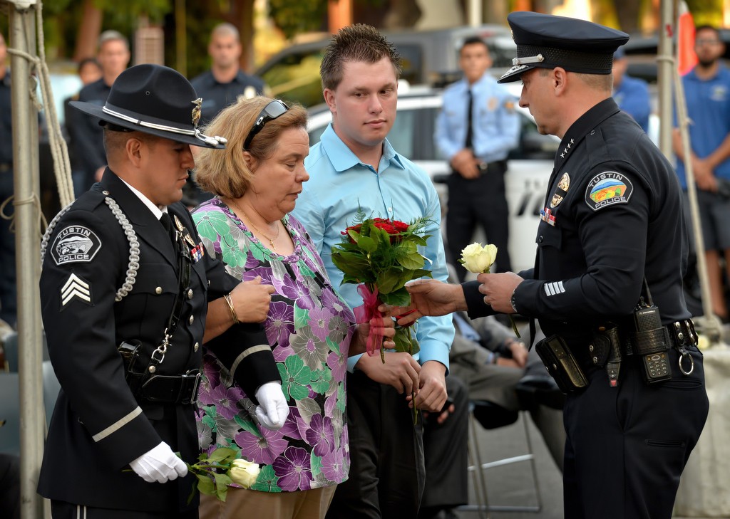 Tustin Police Chief Charles Celano, right, gives Officer Karp’s family a bouquet of roses for them to place at the base of the Tustin PD’s memorial statue. Wally Karp was the only Tustin police officer to be killed in the line of duty. Photo by Steven Georges/Behind the Badge OC