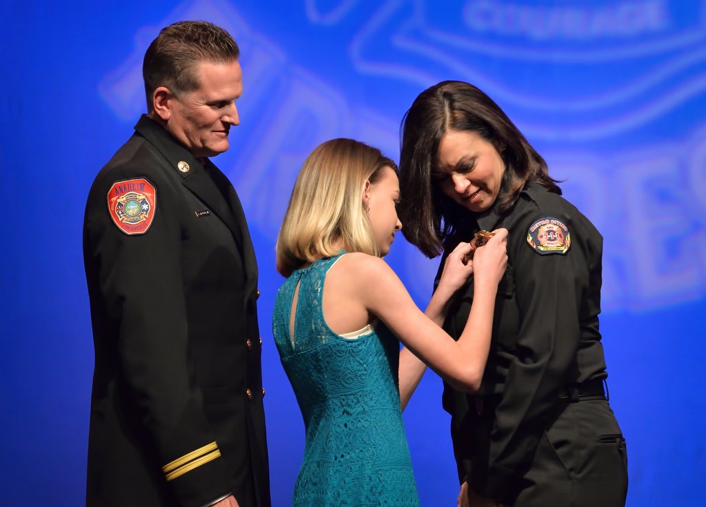 AF&R Metro Net Supervisor Tracy Nolan has her new badge pinned to her by her daughter Jordan Nolan with Anaheim Battalion Chief Bob McClellan next to them. Photo by Steven Georges/Behind the Badge OC