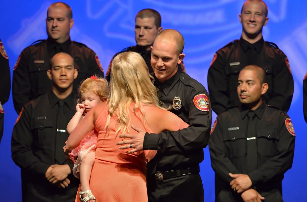AF&R Firefighter Andy McAnally gives his wife Lauren and daughter Hayden a hug after receiving his new badge. Photo by Steven Georges/Behind the Badge OC