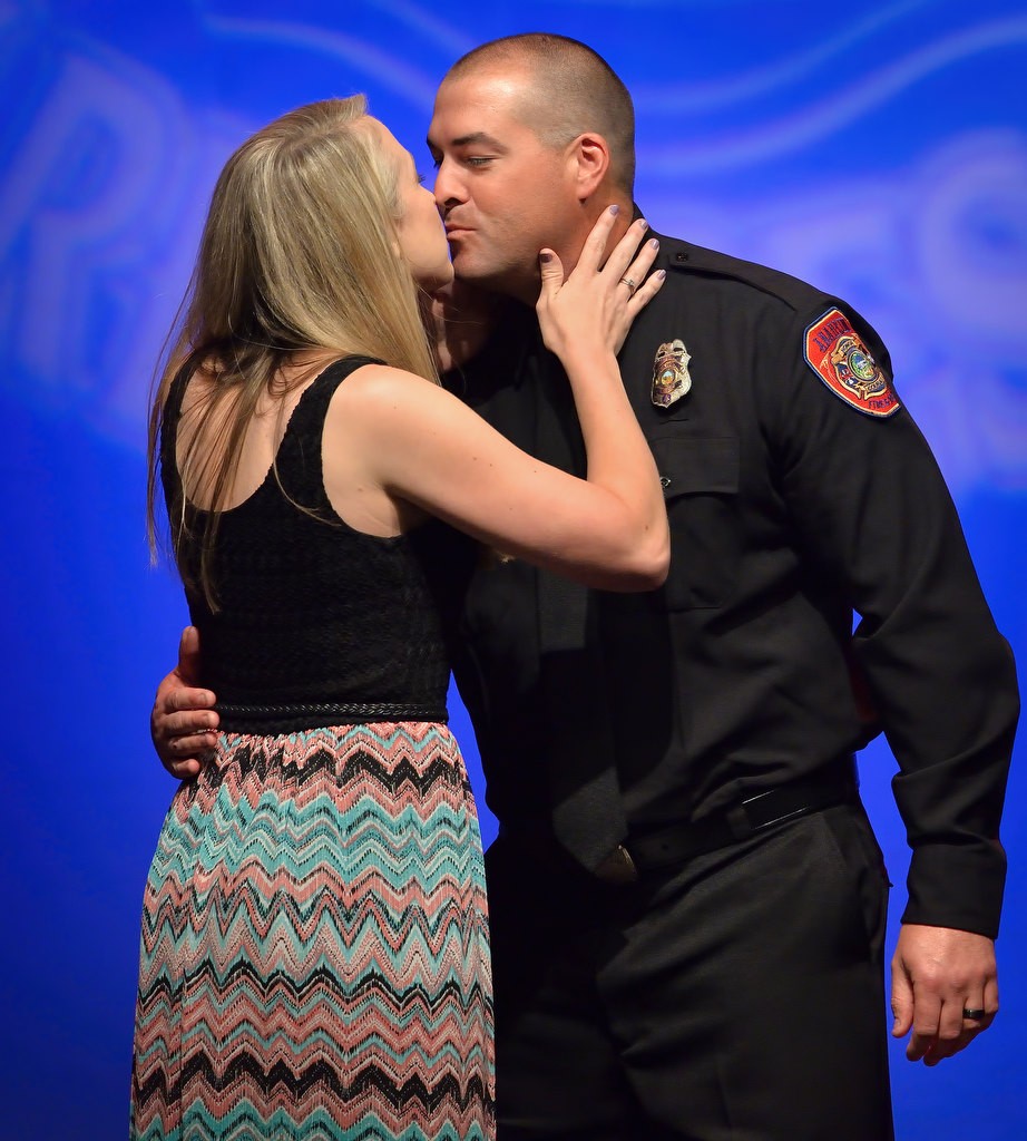 AF&R Firefighter Nathan Turley gets a kiss from his wife Kim after receiving his new badge. Photo by Steven Georges/Behind the Badge OC