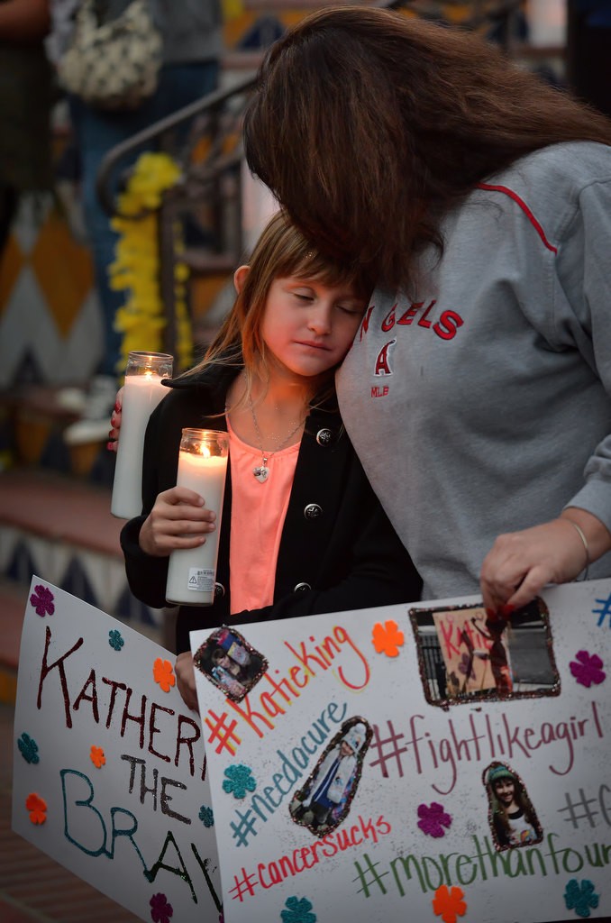 Ava Hermosillo, 7, gives her mother Tina Hermosillo a hug during a candlelight vigil for Katherine King, who was diagnosed with an incurable brain stem tumor, at Fullerton PD’s headquarters. Katherine was too ill to attend but was able to watch the event from her home using a live internet feed. Photo by Steven Georges/Behind the Badge OC