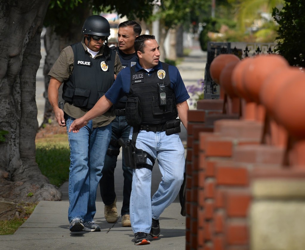 Garden Grove PD Officer Luis Payan leads two other officers as they check the neighborhood as they serve a warrant on a house on Palmer St. in Compton in connection to the Lottery Scratchers burglars. Photo by Steven Georges/Behind the Badge OC