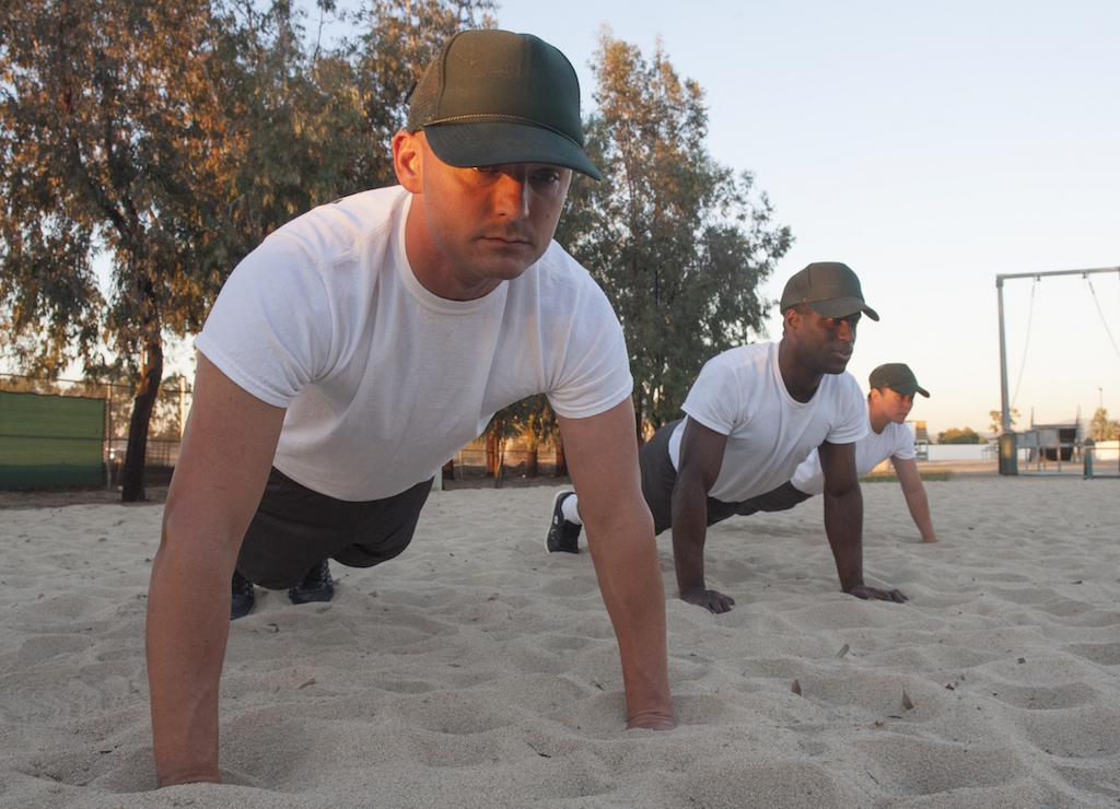 Tustin PD recruit David Valencia holds a pushup position on the Beach at the Orange County Sheriff's Regional Training Academy. The Beach is where recruits do most of their physical training. Photo by Miguel Vasconcellos/Behind the Badge OC. 