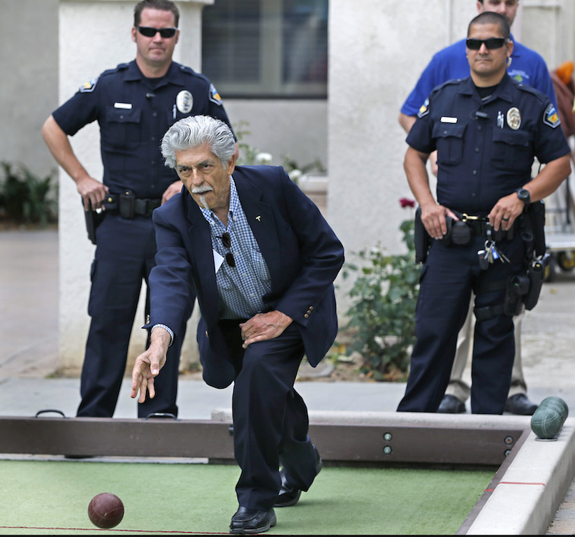 Tustin PD's Charles Mitchell, and Shonn Rojas keep an eye on the competition during a Bocce Ball Tournament against members of the Senior Center. Photo by Christine Cotter/Behind the Badge 