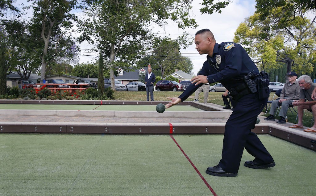 Tustin PD's Sinclair Alfonso concentrates on his throw in a bocce ball match against members of the Tustin Senior Center.  Photo by Christine Cotter/Behind the Badge OC 