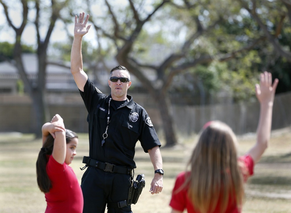 Tustin Police Department's Officer Matthew Roque demonstrates proper stretching techniques to Heideman Elementary school students.  Photo by Christine Cotter/Behind the Badge OC 