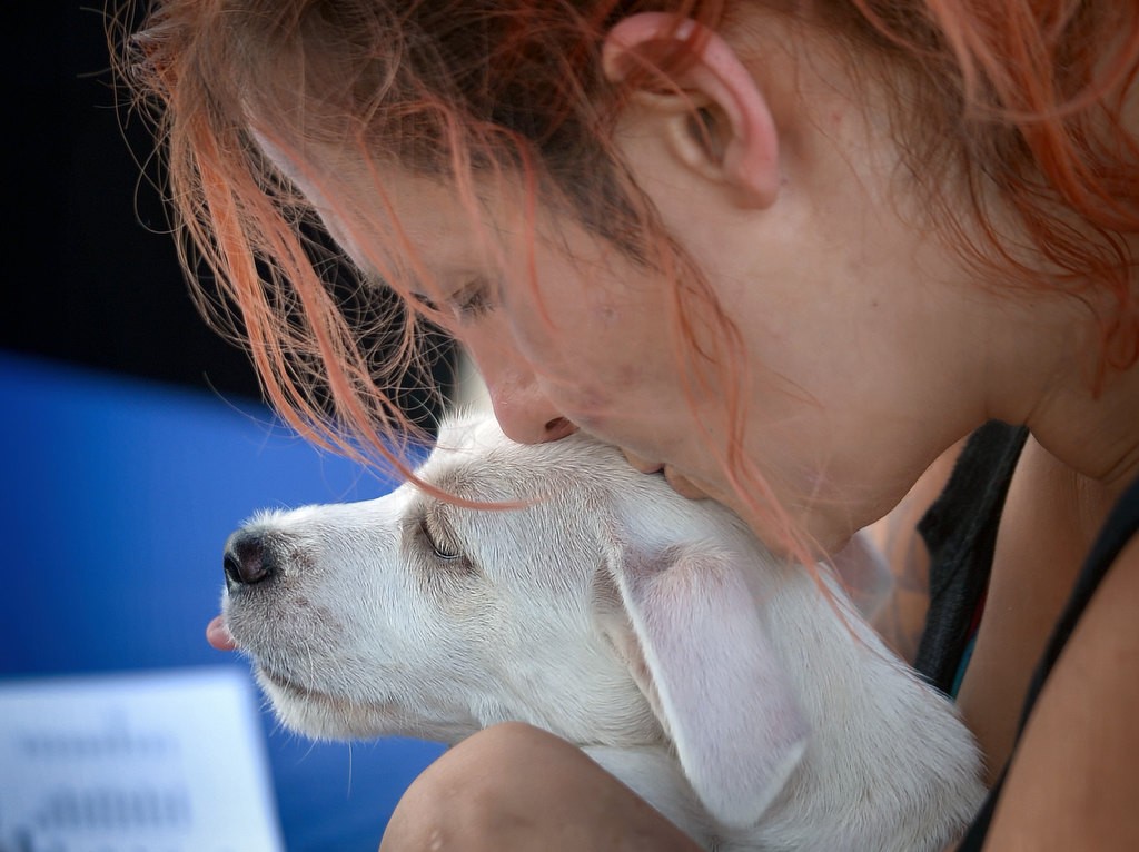Candice Mello, a homeless woman who has been living in the flood canal under Western Ave. for a fews months, gives her dog Spaz a hug while she talks to health care professionals about her options after the Garden Grove Homeless Task Force moved her and others out. Photo by Steven Georges/Behind the Badge OC