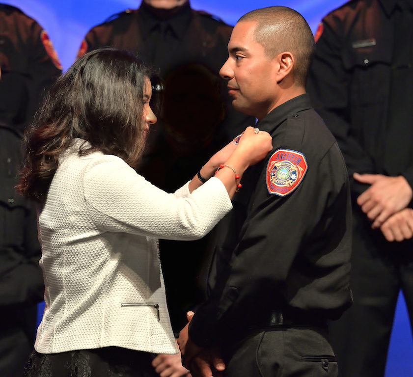 AF&R Firefighter Alex Miranda gets his new badge pinned to him by his wife Iris Miranda. Photo by Steven Georges/Behind the Badge OC