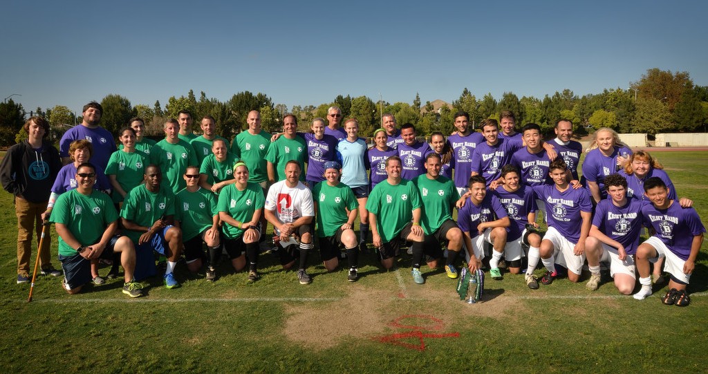 Soccer players from Tustin and Irvine PD, green shirts, Beckman High School, purple shirts, and the Harris family gather at the conclusion of the Kelsey Harris Memorial soccer game at Beckman High to raise money and awareness for Lafora research. Photo by Steven Georges/Behind the Badge OC