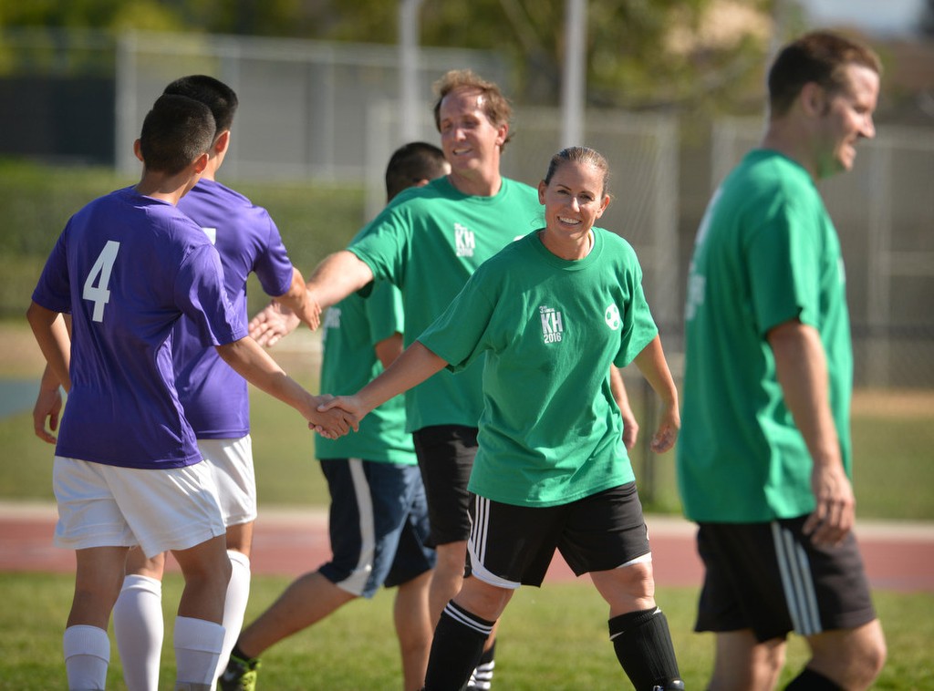 Tustin and Irvine police,green shirts, congratulate players from Beckman High School at the conclusion of the charity soccer game. Photo by Steven Georges/Behind the Badge OC