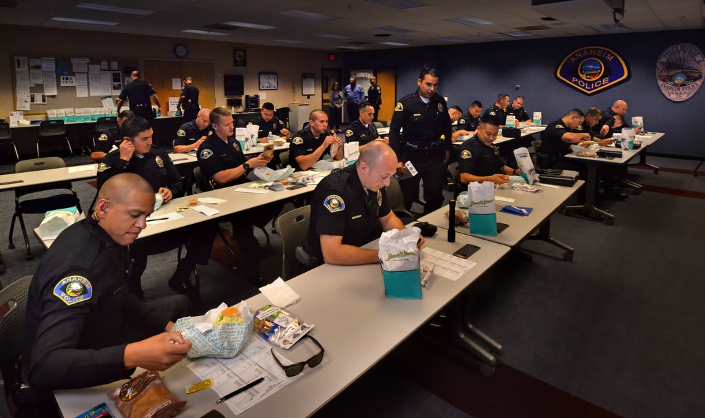 Anaheim PD officers, during their briefing, enjoy their free lunch for Law Enforcement Appreciation Week. Photo by Steven Georges/Behind the Badge OC