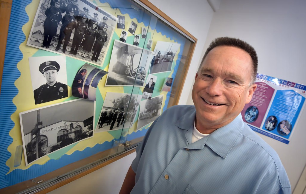 Retired FPD Detective Bill Wallace stands in front of a collage of old photographs of the department from the mid to early 1950’s. “Part of my love for the (Fullerton Police) department is the history of the department,” said Wallace when talking about why he also works as the unofficial historian. Photo by Steven Georges/Behind the Badge OC