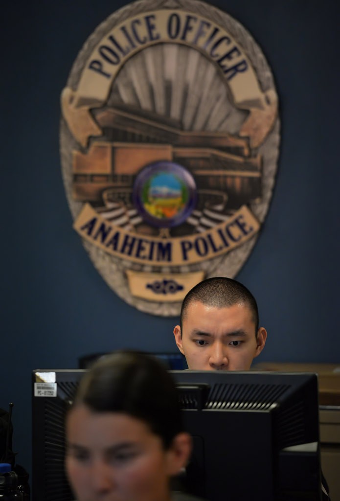 Anaheim PD Cadet Jiwon Kim helps with the administrative computer work at the front desk at police headquarters. Photo by Steven Georges/Behind the Badge OC