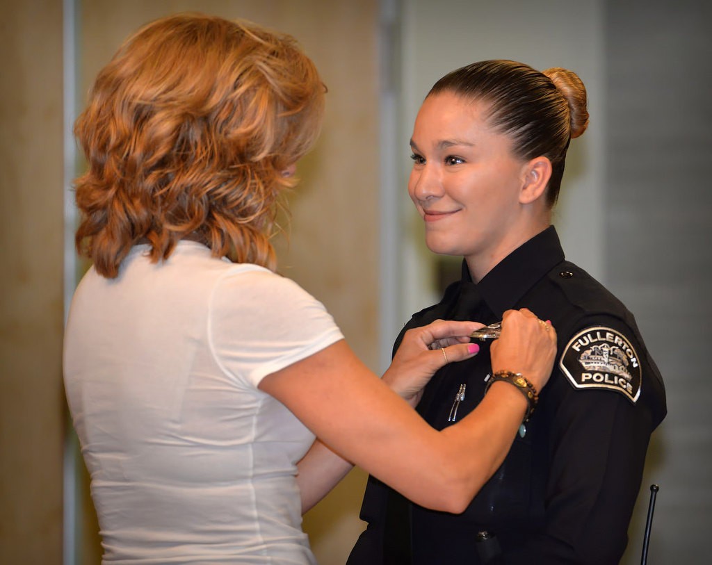 Fullerton’s new Police Officer Danielle Riedl receives her new badge from her mother Trish during a ceremony in Fullerton. Photo by Steven Georges/Behind the Badge OC