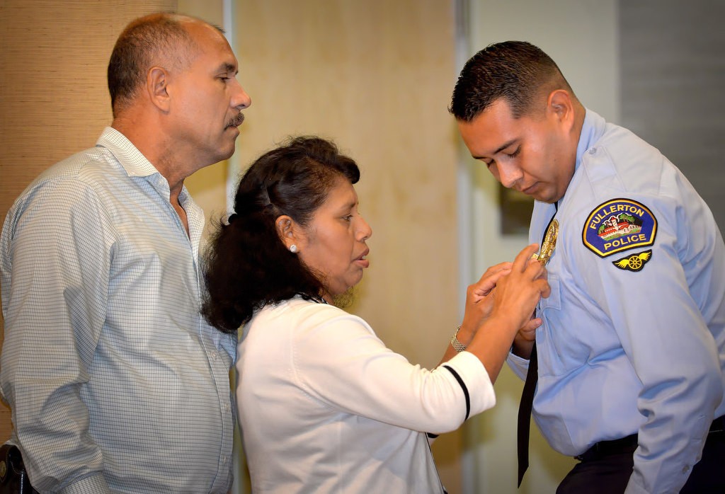 Luis Rubio receives his new badge as FPD Parking Control Aide from his mother Domitila and father Luis. Photo by Steven Georges/Behind the Badge OC