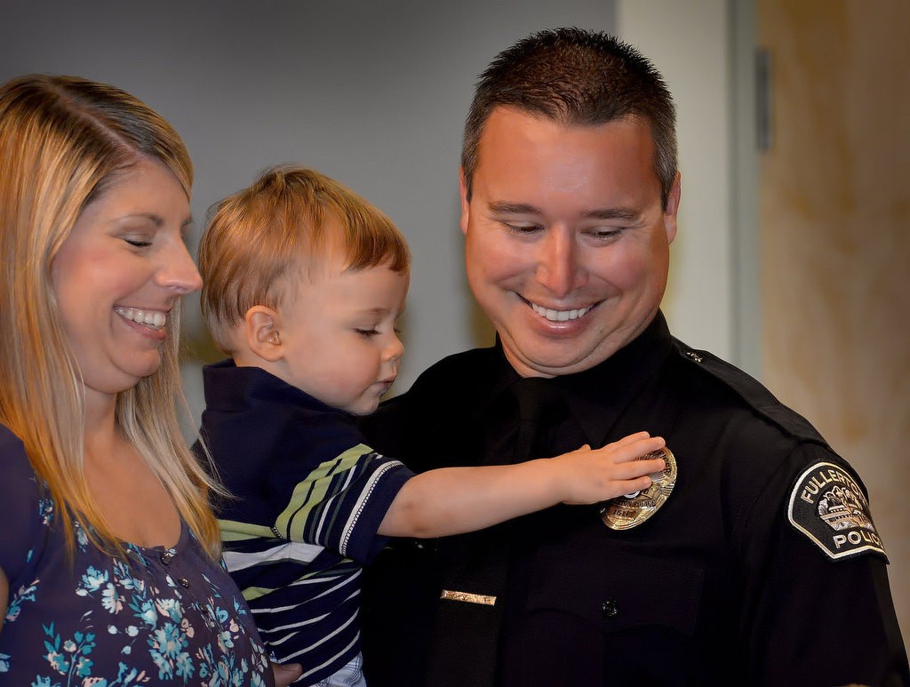 Fullerton Police Officer Jeffrey Beaty’s son Zachary checks out his dad’s new badge during a ceremony in Fullerton. Photo by Steven Georges/Behind the Badge OC