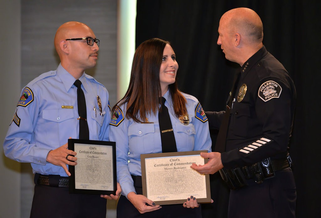 Cesar Navarro, and Marnie Rodriguez receive the Chief’s Certificate of Commendation from Chief Dan Hughes for their extra effort in tracking down and relaying critical information to officers on the scene about a suspect having access to a firearm before a fatal officer‐involved shooting occurred. Photo by Steven Georges/Behind the Badge OC