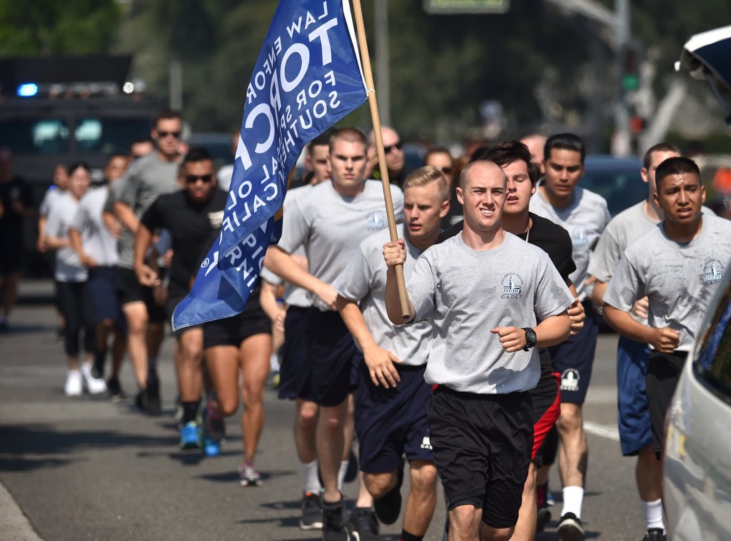 Members of the Fullerton PD and Special Olympians run across Chapman Ave. during the Law Enforcement Torch Run for Special Olympics of Southern California. Photo by Steven Georges/Behind the Badge OC