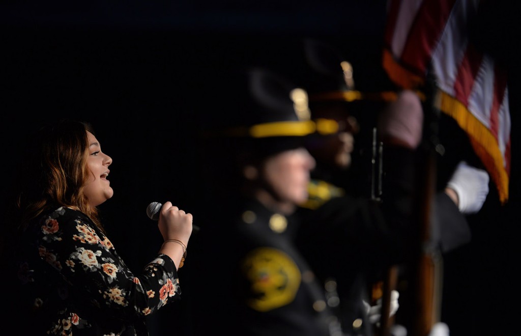 Elizabeth Kunce sings the National Anthem next to the Color Guard during the Orange County Sheriff's Regional Training AcademyÕs Class of 220 graduation ceremony. Photo by Steven Georges/Behind the Badge OC