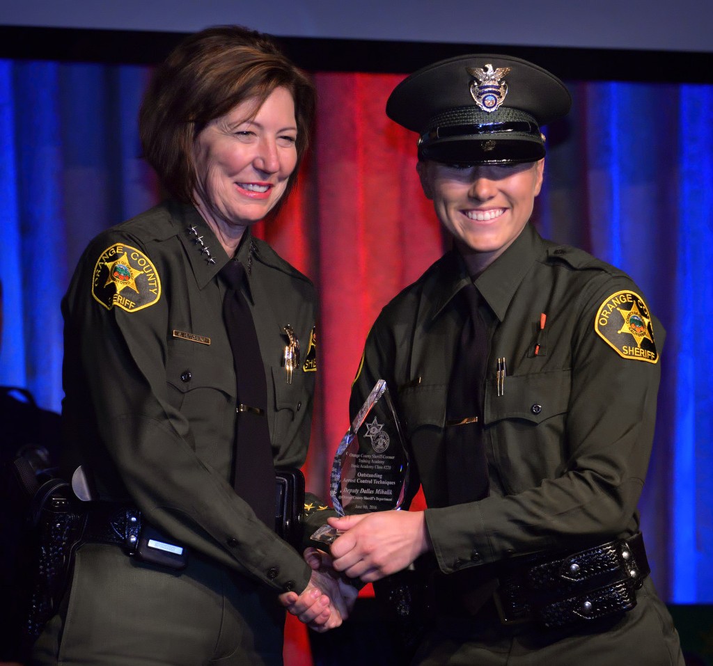 Orange County Sheriff Sandra Hutchens presents one of OCSD's newest deputies, Dallas Mihalik, with the Outstanding Arrest Control Techniques award during the Orange County Sheriff's Regional Training AcademyÕs Class of 220 graduation ceremony. Photo by Steven Georges/Behind the Badge OC