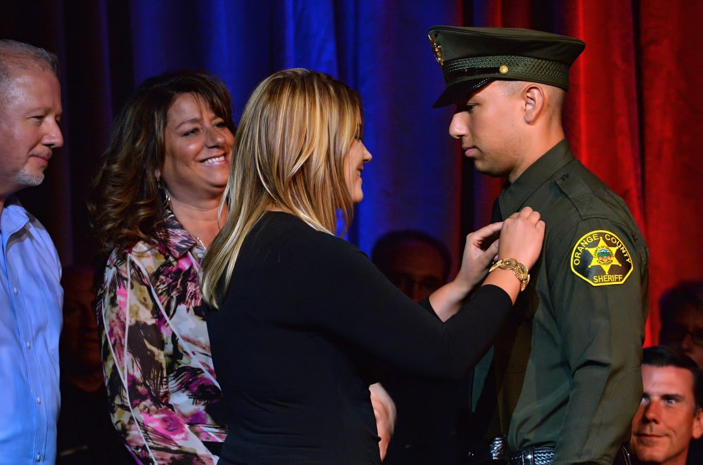 OCSD Deputy Kyle Deaton gets his new badge pinned onto him by his wife Hailey with his mother Wende and father Mark next to him. Photo by Steven Georges/Behind the Badge OC