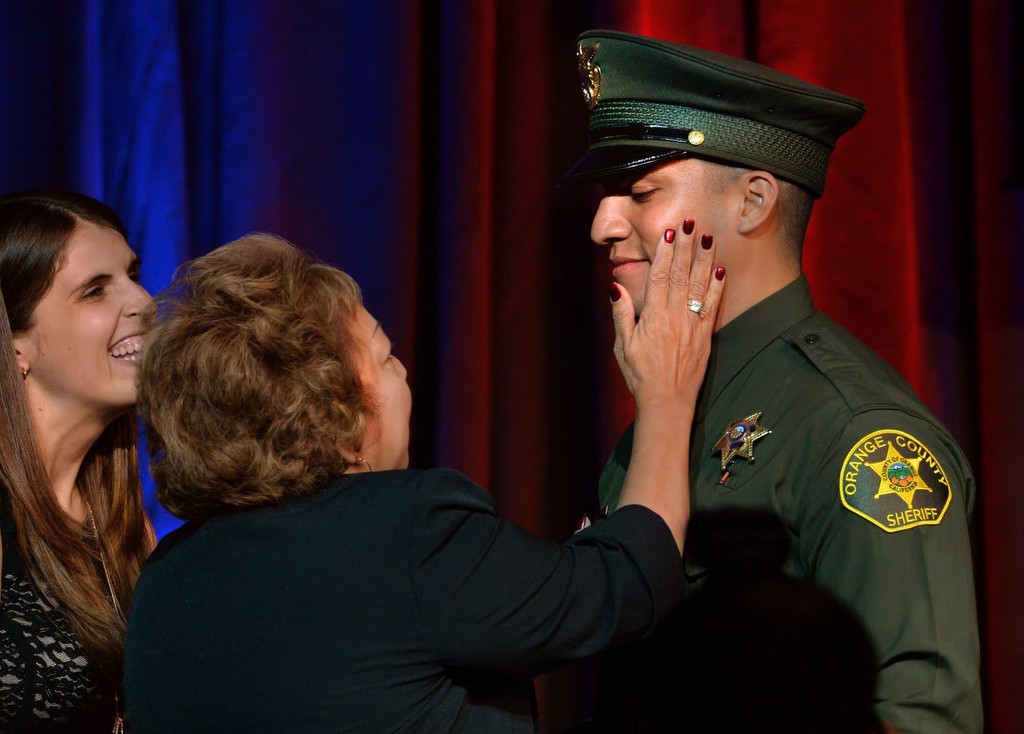 Deputy Christopher Rosales smiles as his mother Patricia shows her pride in her son with his girlfriend Jennifer, left, after receiving his new badge during the Orange County Sheriff's Regional Training AcademyÕs graduation ceremony. Photo by Steven Georges/Behind the Badge OC