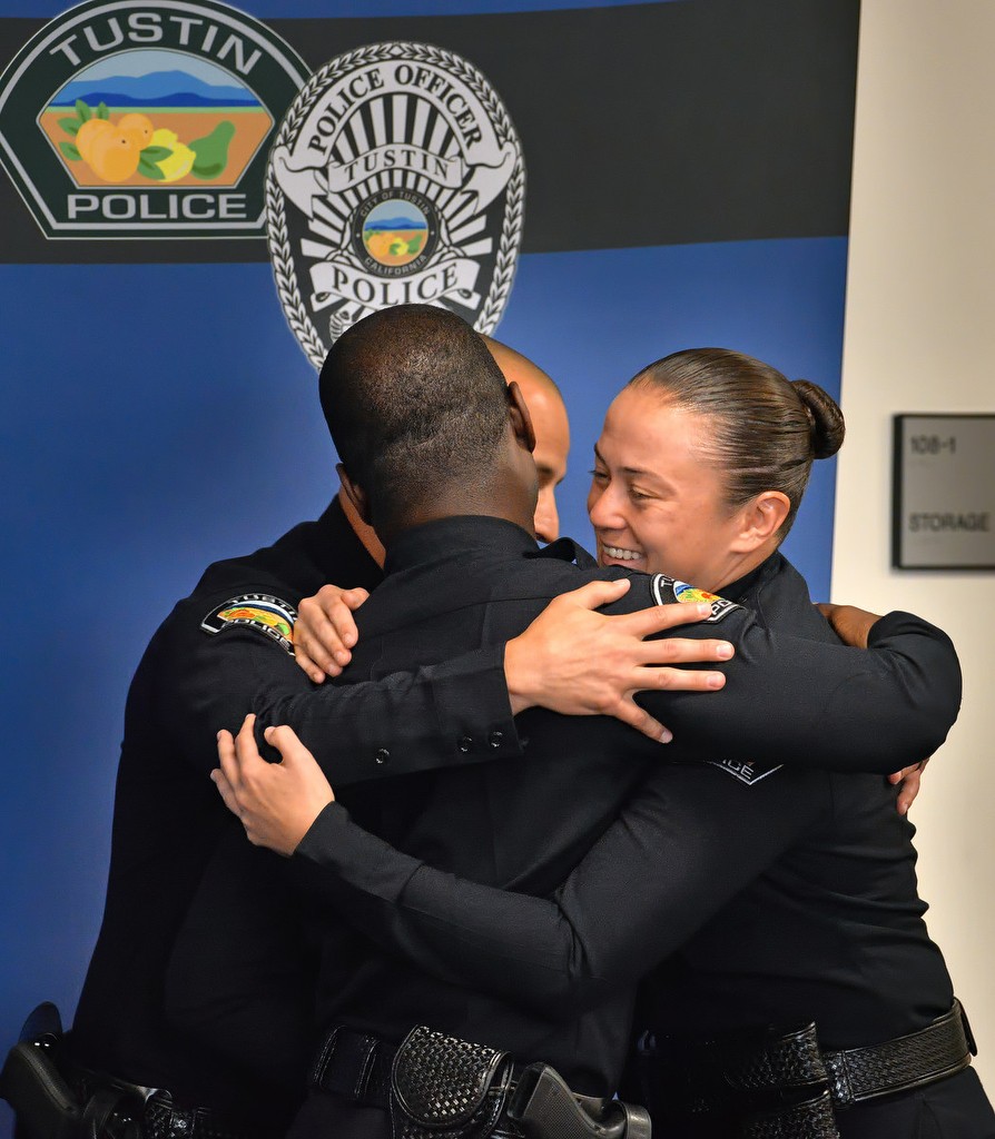 Officers David Valencia, Ismael Aurelus and Leah Barrett give each other a group hug after being sworn in by Tustin Police Chief Charles Celano as Tustin PD's newest officers. Photo by Steven Georges/Behind the Badge OC