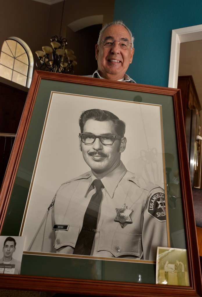 Ron Reyes, who retired from the Orange County Sheriff Department, with an old photo of himself as a Los Angeles County Sheriff Deputy. Photo by Steven Georges/Behind the Badge OC
