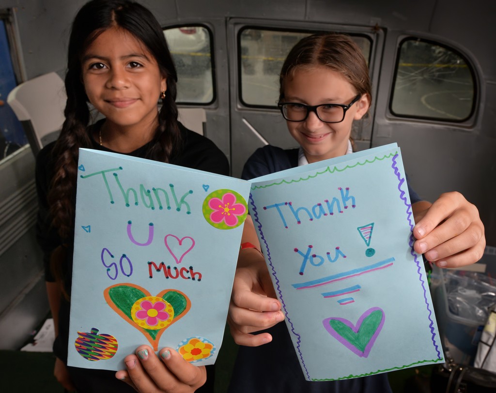 Vanessa Pinzon, 12, left, and Cali Fields, 10, hold the thank you cards they made for the Tustin Police while inside the Team Kids bus during the Tustin PD’s Run Club at Robert Heideman Elementary. Photo by Steven Georges/Behind the Badge OC