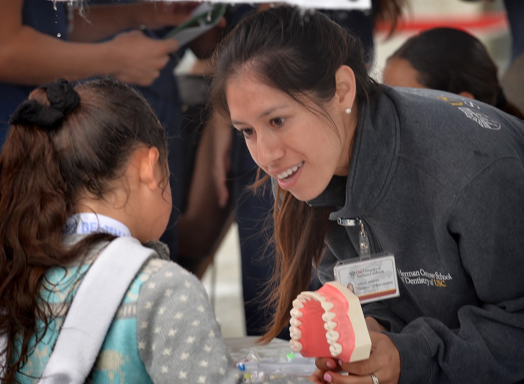 USC school of dentistry student Jennifer Garcia shows kids proper techniques for brushing your teeth at the Dental Care for Children booth during Tustin PD’s Run Club at Robert Heideman Elementary. Photo by Steven Georges/Behind the Badge OC