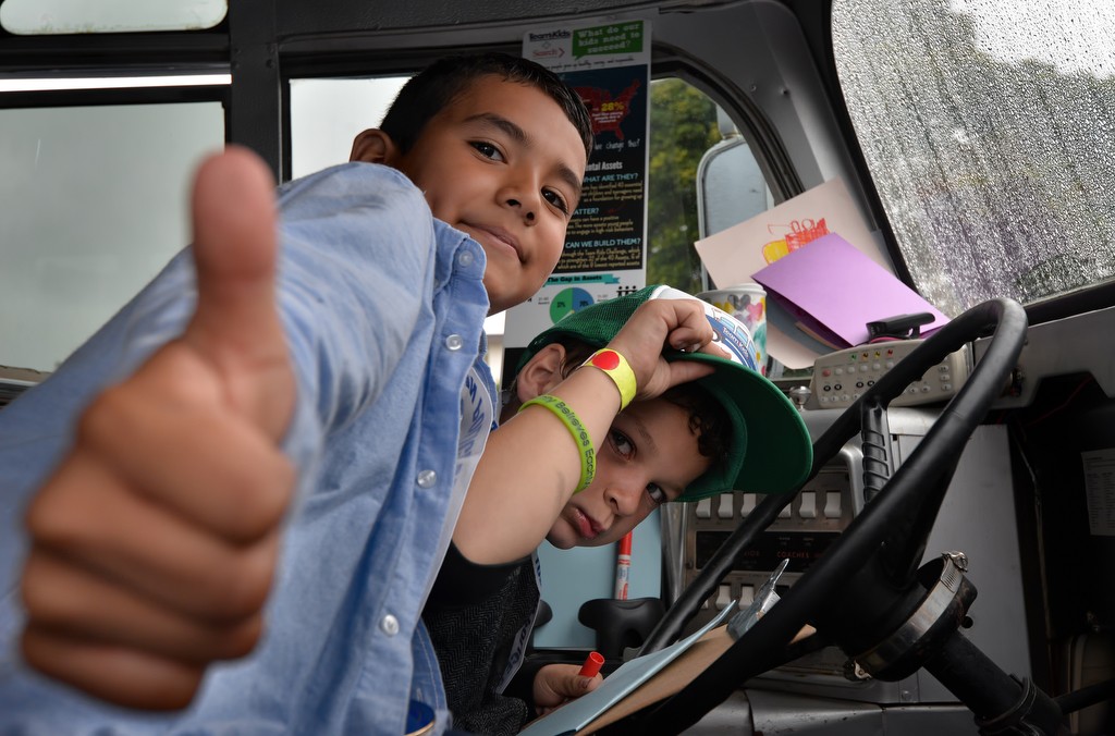 Alfonso Melchor, 10, left, and Jayden Fields, 8, both from Heideman Elementary, have fun at the wheel of a “Stationary” Team Kids bus during Tustin PD’s Run Club. Photo by Steven Georges/Behind the Badge OC