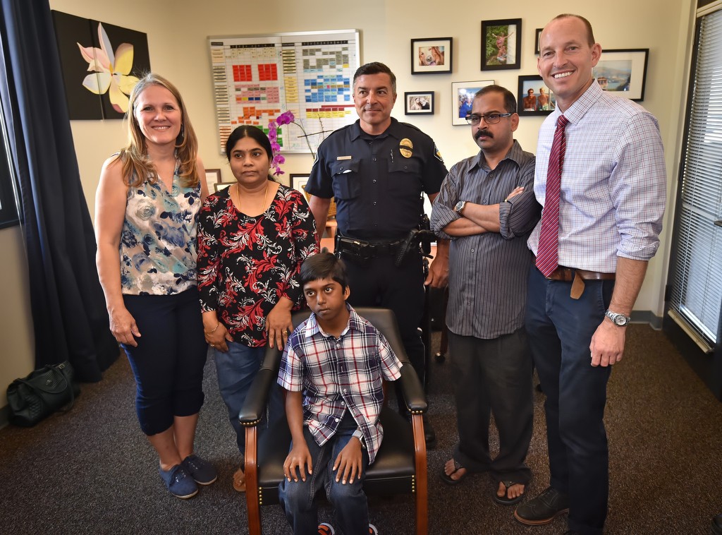 Siva Pelluru, 13, of Pioneer Middle School in Tustin visits the school to thank Tustin PD Officer Ralph Casiello and Pam Atkins, the school nurse, who helped save the boys life after he collapsed due to a full cardiac arrest at the school. Behind him from left is RN Pam Atkins, mother Saraswathi Pelluru, Tustin PD Officer Ralph Casiello, dad Prabha Pelluru and Pioneer Assistant Principal Troy Fresch. Photo by Steven Georges/Behind the Badge OC
