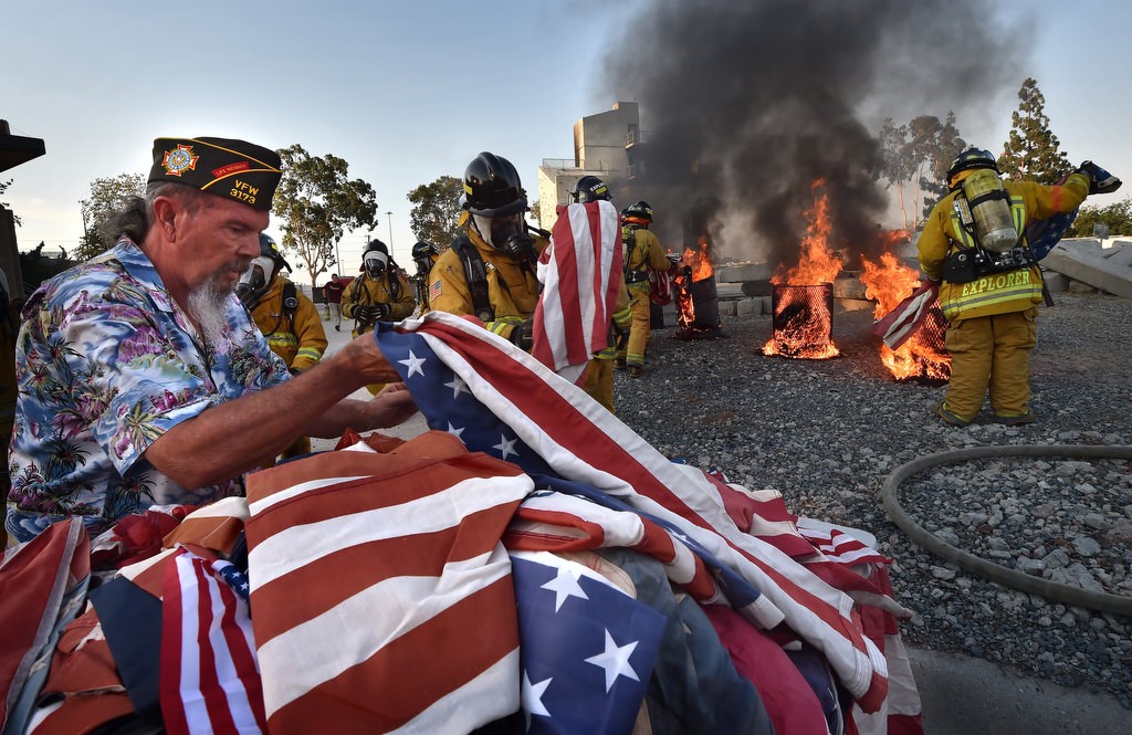 American flags are sorted and prepared to disposal in the fires behind during a flag burning ceremony at the North Net Fire Training Center in Anaheim. Photo by Steven Georges/Behind the Badge OC