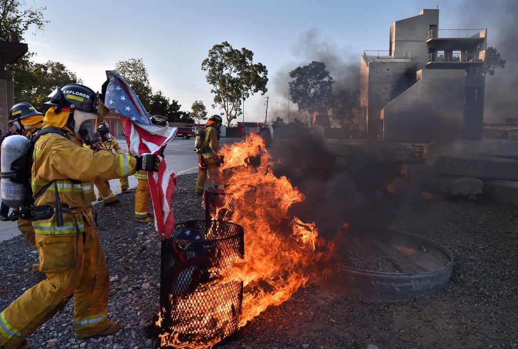 Cadets from the City of Orange fire department fold up an American flag before proper disposal during a flag burning ceremony at the North Net Fire Training Center in Anaheim. Photo by Steven Georges/Behind the Badge OC