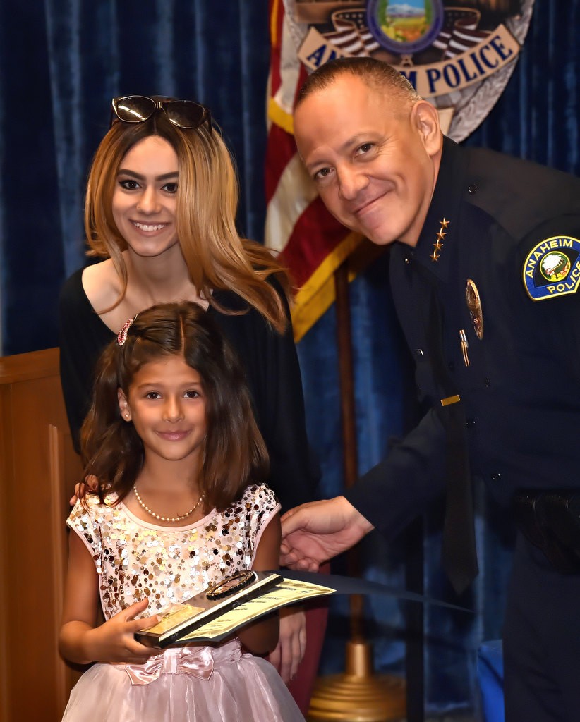 Ray Allison, first grade student from Stoddard Elementary, receives a Do the Right Thing award from Aviella Winder, left, and Anaheim Police Chief Raul Quezada. Photo by Steven Georges/Behind the Badge OC