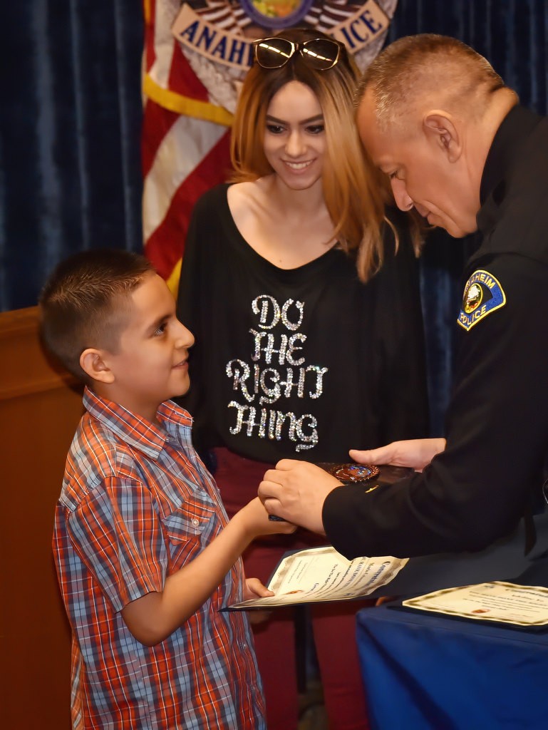 Mario Mendoza, a third grade student from Betsy Ross Elementary School, receives his Do the Right Thing award from Anaheim Police Chief Raul Quezada, with Aviella Winder behind them, during an awards ceremony at the police headquarters. Photo by Steven Georges/Behind the Badge OC