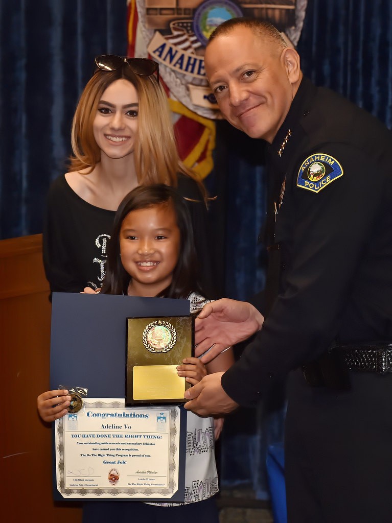 Adeline Vo, forth grade student from Stoddard Elementary School, receives her Do the Right Thing award from Aviella Winder, left, and Anaheim Police Chief Raul Quezada. Photo by Steven Georges/Behind the Badge OC