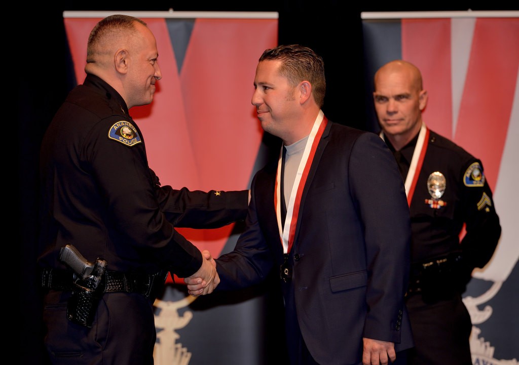 Officer Eric Anderson, right, is congratulated by Anaheim Police Chief Raul Quezada as Degn receives the Lifesaving Award. Behind them is Erik Degn, right. Photo by Steven Georges/Behind the Badge OC