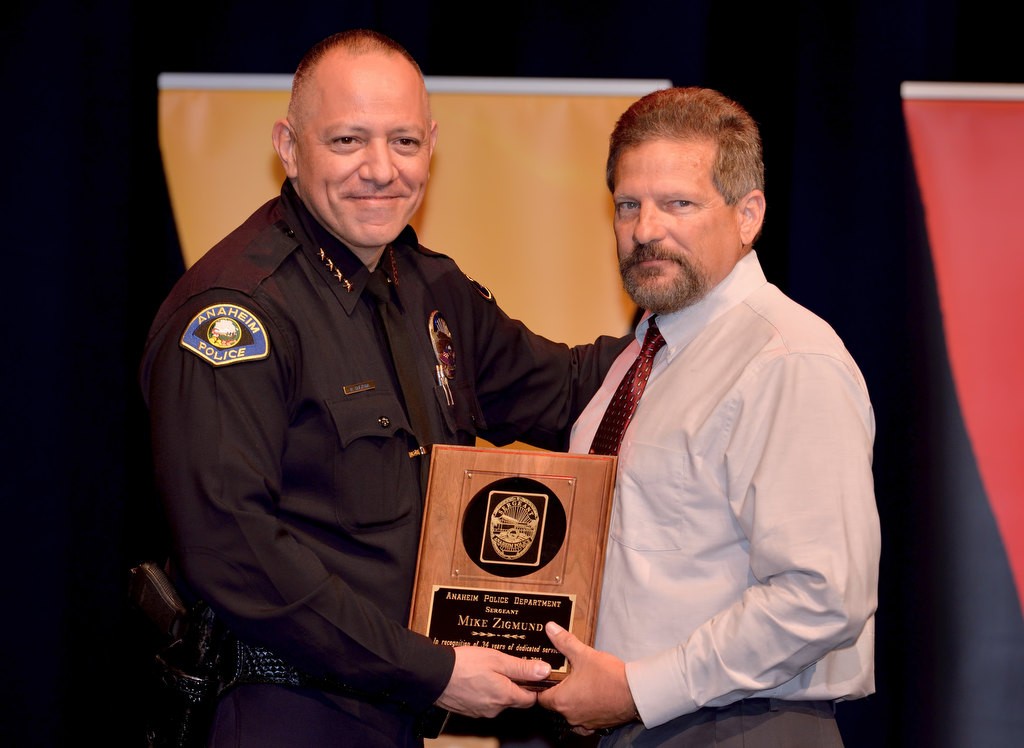 APD Sgt. Mike Zigmund, right, receives recognition for 34 years of service from Anaheim Police Chief Raul Quezada. Photo by Steven Georges/Behind the Badge OC
