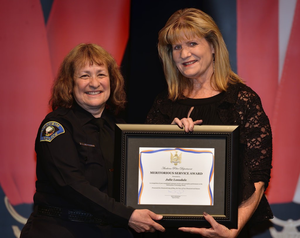 Julie Lonsdale, right, receives the Meritorious Service Award from Commander Shelley McKerren. Photo by Steven Georges/Behind the Badge OC