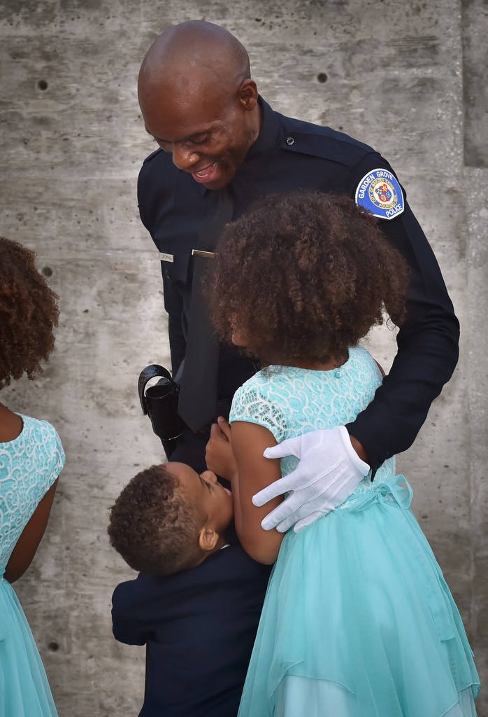 Garden Grove PD Reserve Officer John Ojeisekhoba gives some of his kids a hug at the end of LASD graduation ceremonies. Photo by Steven Georges/Behind the Badge OC