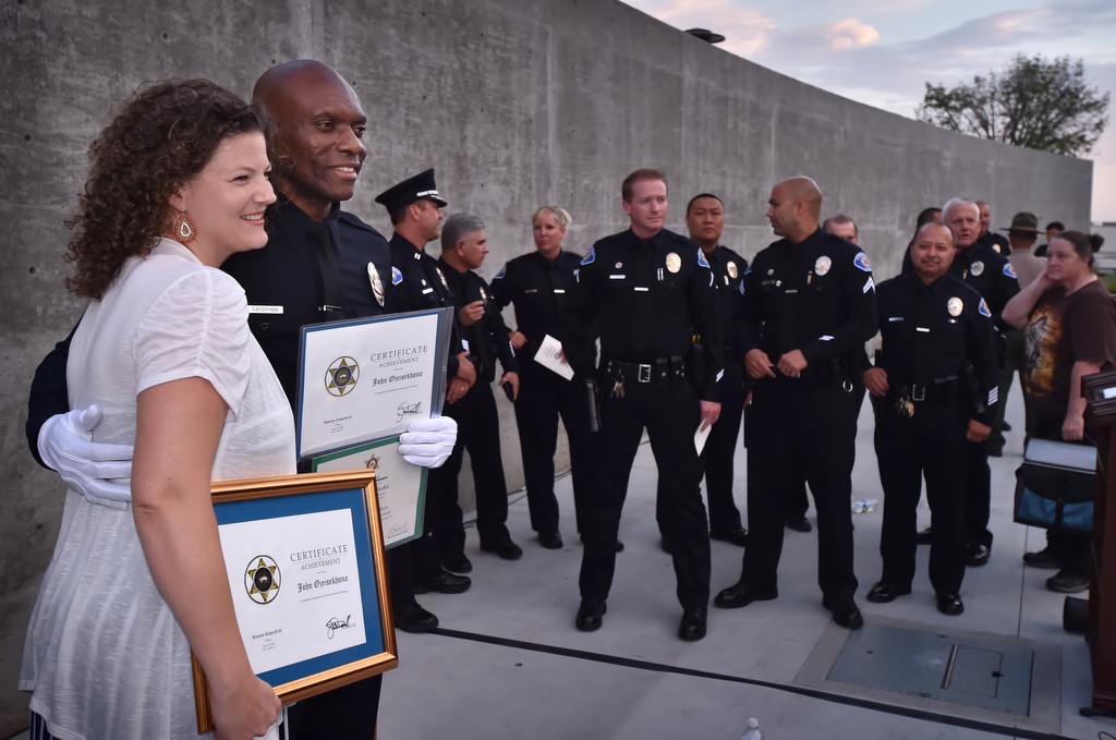 Garden Grove PD Reserve Officer John Ojeisekhoba with his wife Heidi and fellow Garden Grove Police officers, behind them, after graduation ceremonies. Photo by Steven Georges/Behind the Badge OC