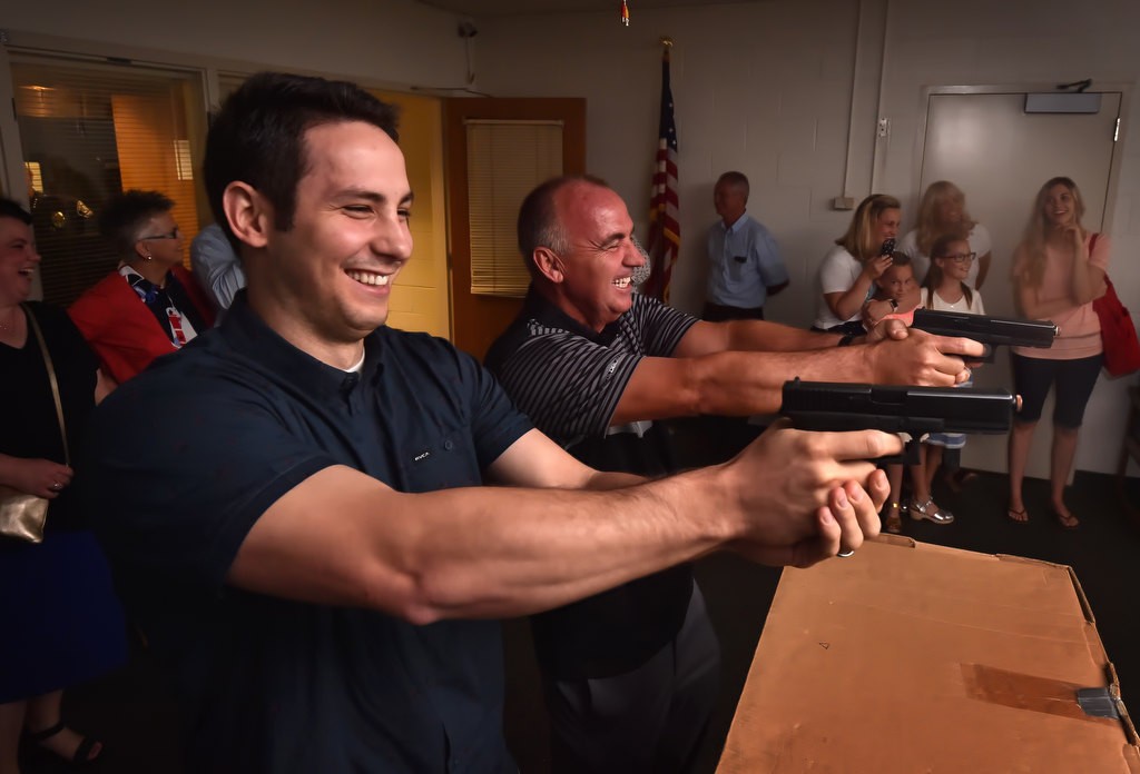 Travis Hatch, left, and Ron Hatch try out the laser shooting simulator during a tour of Fullerton PD headquarters for family members and friends of the late Fullerton PD Officer Jerry Hatch. Photo by Steven Georges/Behind the Badge OC