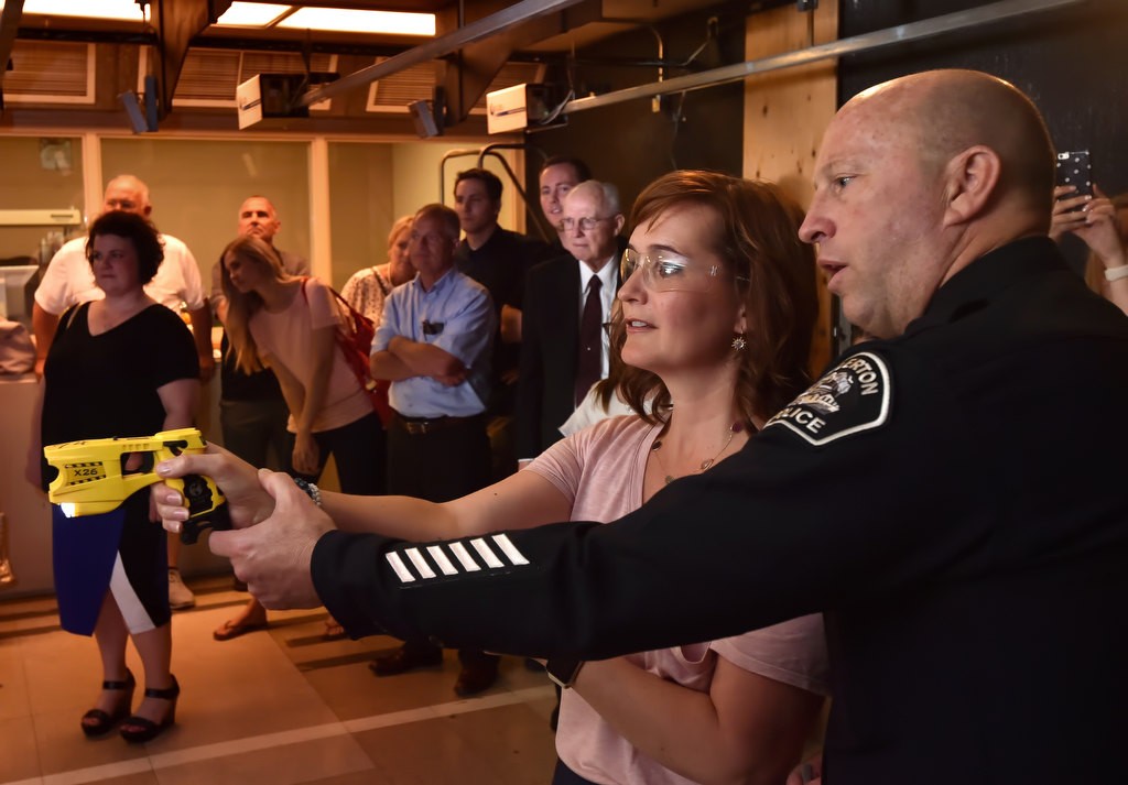 Fullerton PD Chief Dan Hughes gives instructions on how to use a TASER to Andrea Nielson, niece of fallen Officer Jerry Hatch, at Fullerton PD shooting range during a tour for family members. Photo by Steven Georges/Behind the Badge OC