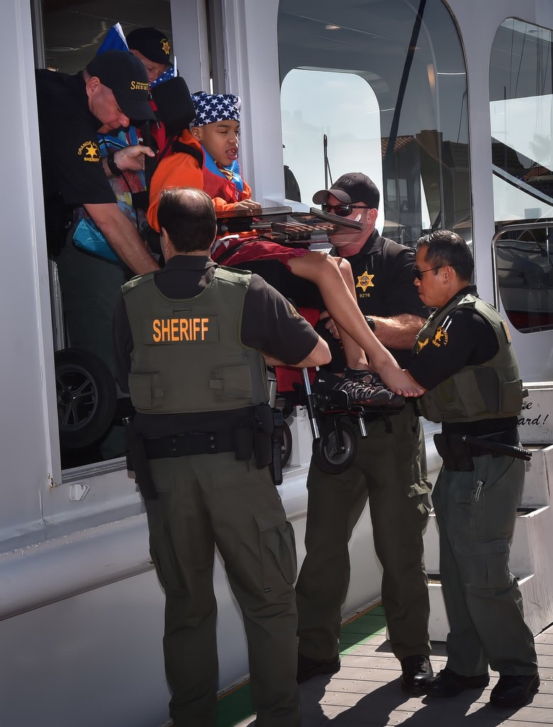 Orange County Sheriff Deputies help kids off the boat during a 4th of July Newport Harbor Cruise. Photo by Steven Georges/Behind the Badge OC